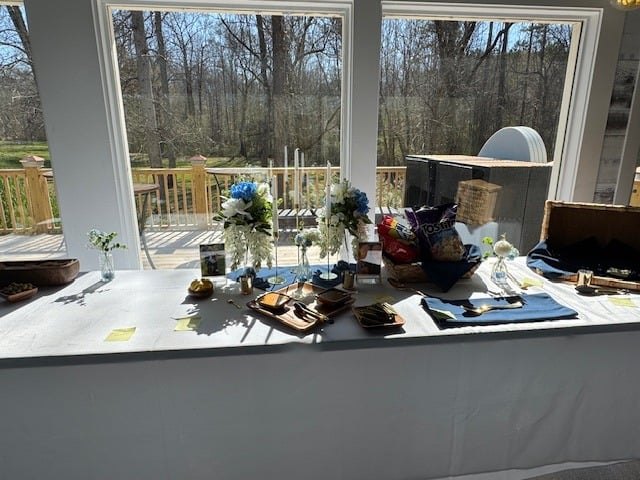 Head table set beside the wall of glass overlooking the woods