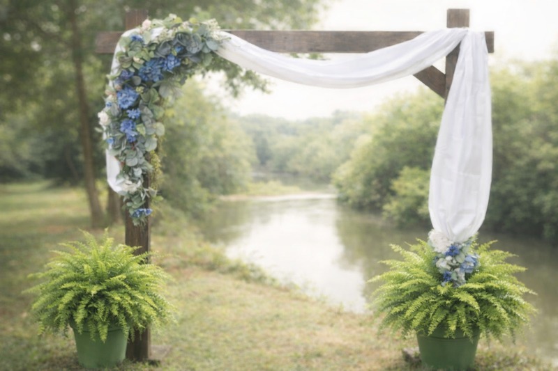 Floral ceremony arch draped in white fabric on the bank of the Etowah River
