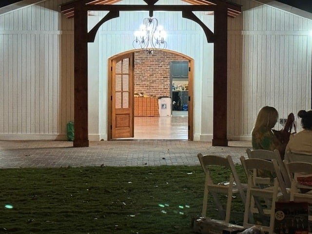 Rows of white chairs facing the pavilion's brick archway before a ceremony